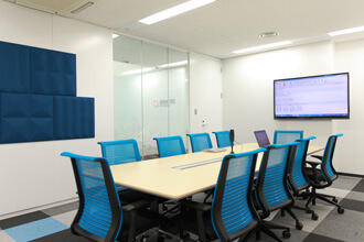 社内外での打合せで使用する会議室。壁にはデザイン的にも優れた 吸音板を備えている。